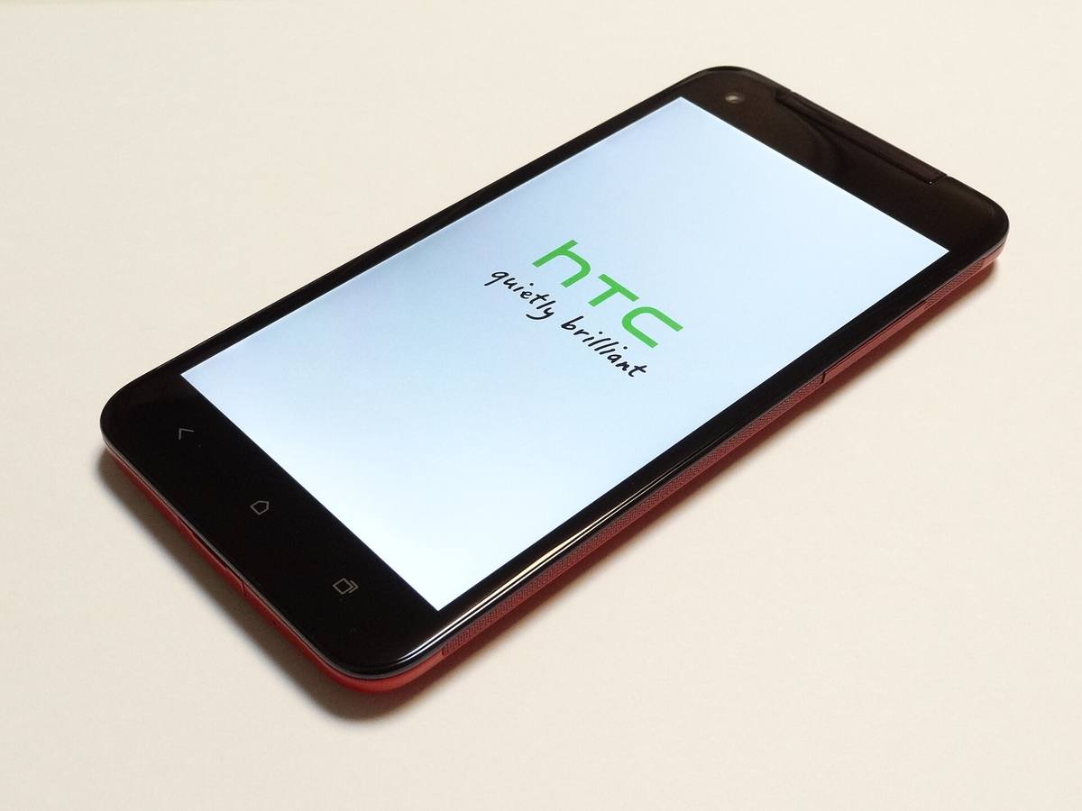 Černý telefon HTC J butterfly leží displejem vzhůru