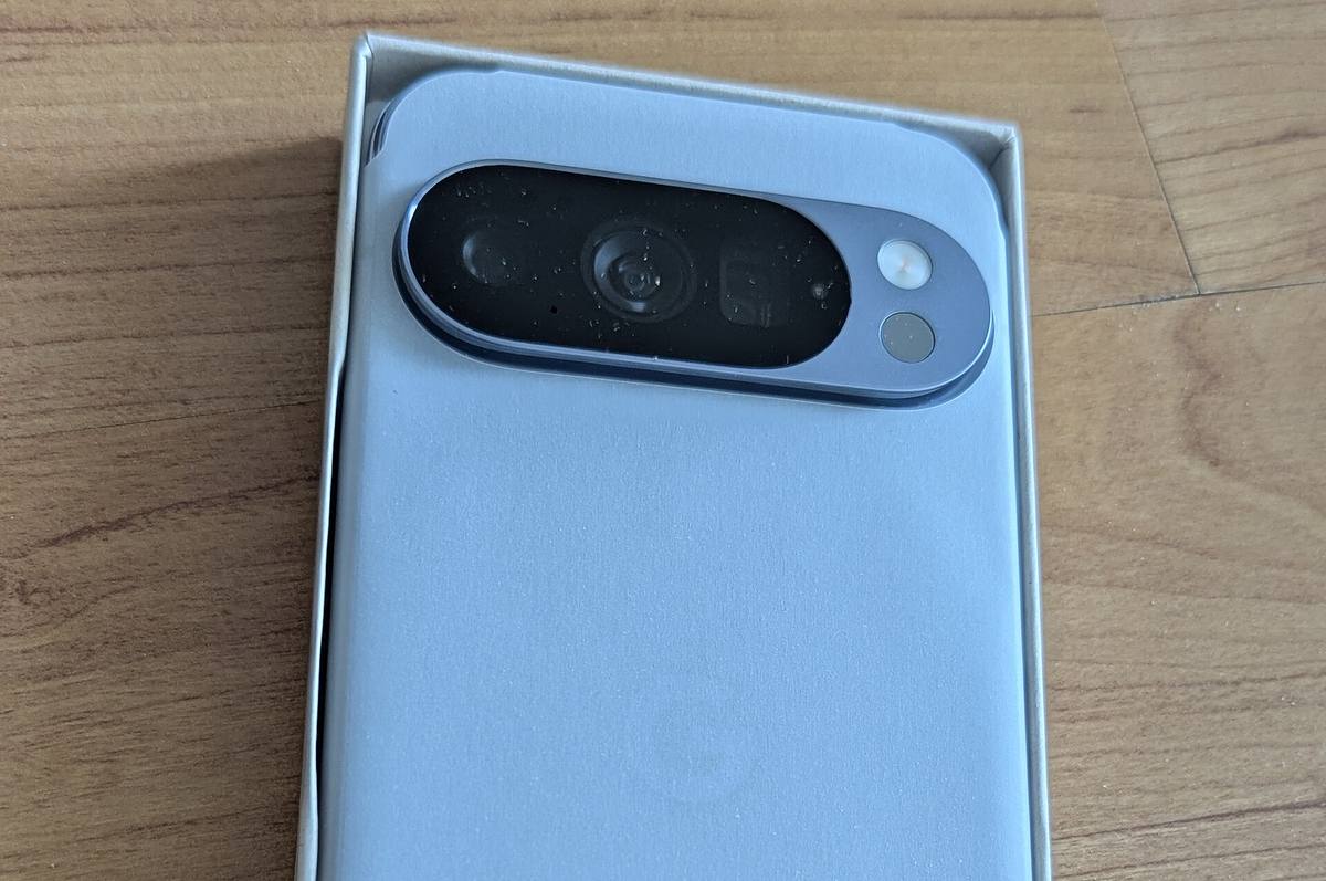 Zadní strana telefonu Google Pixel 10 Pro v otevřené krabici, nahoře vodorovná lišta se třemi fotoaparáty
