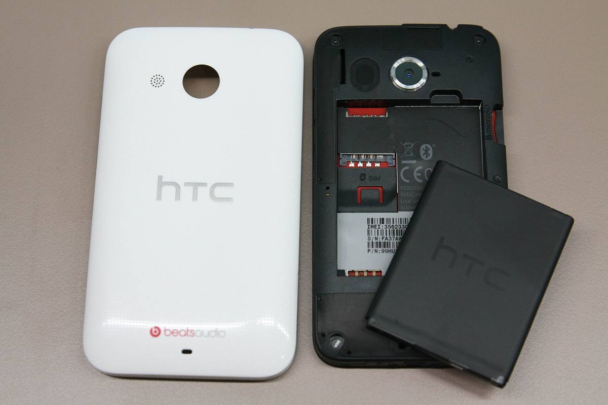 Sundaný zadní kryt telefonu HTC, vedle něj vyjmutá baterie