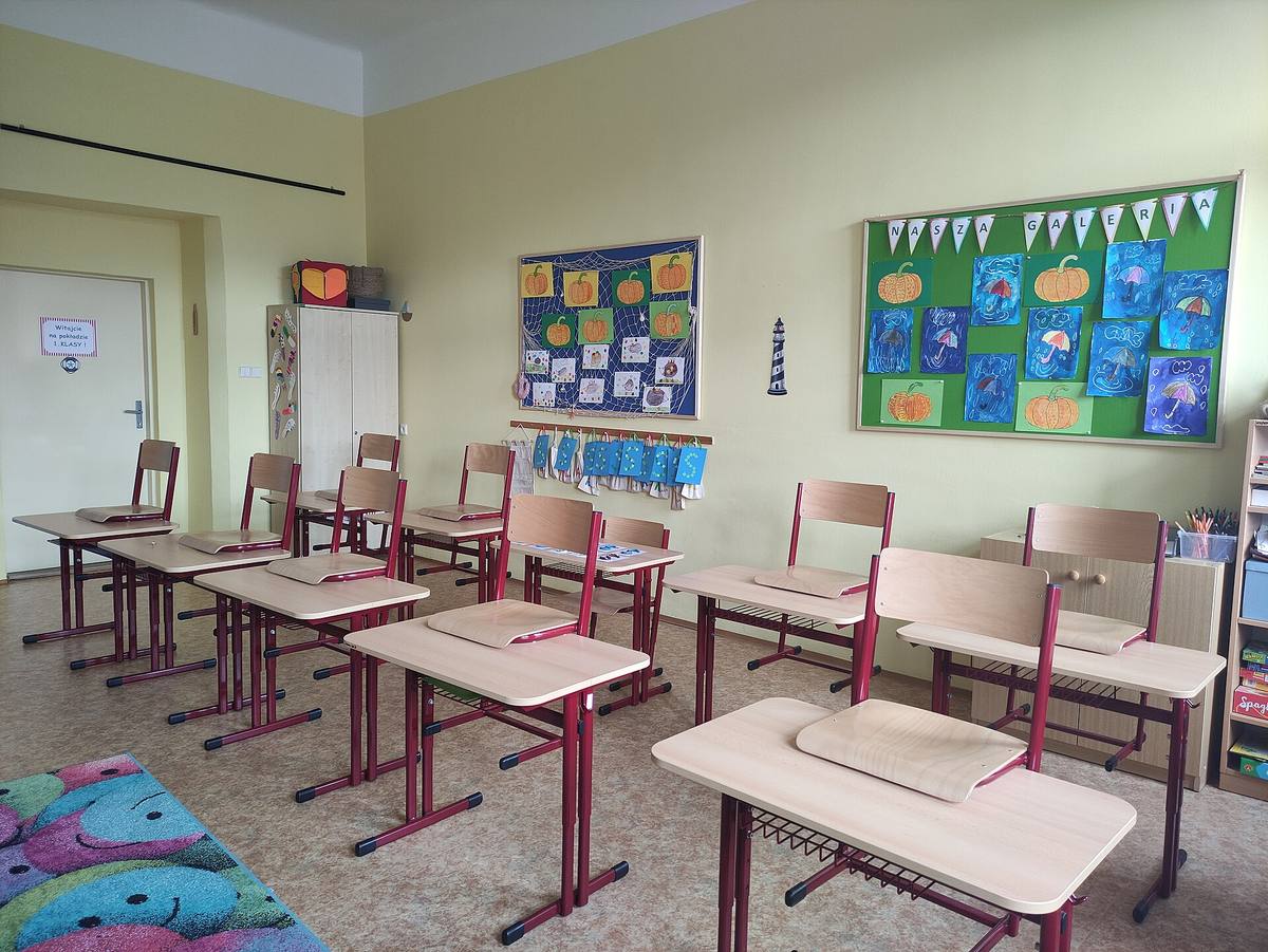 Prázdná učebna první třídy s lavicemi a nástěnkami dětských kreseb