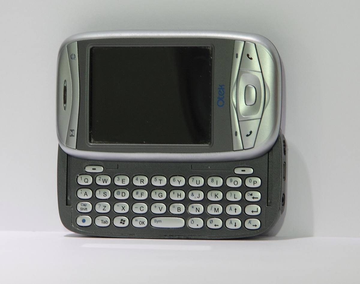 Komunikátor Qtek 9100 s vysunutou klávesnicí QWERTY, položený na boku