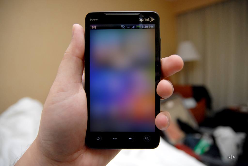 Ruka drží černý telefon HTC EVO 4G, nahoře logo HTC a logo Sprint