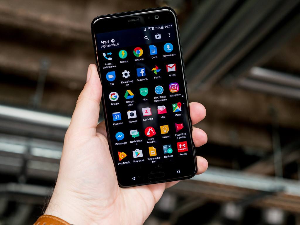 HTC U11 držené v jedné ruce, prsty obepínají boky telefonu