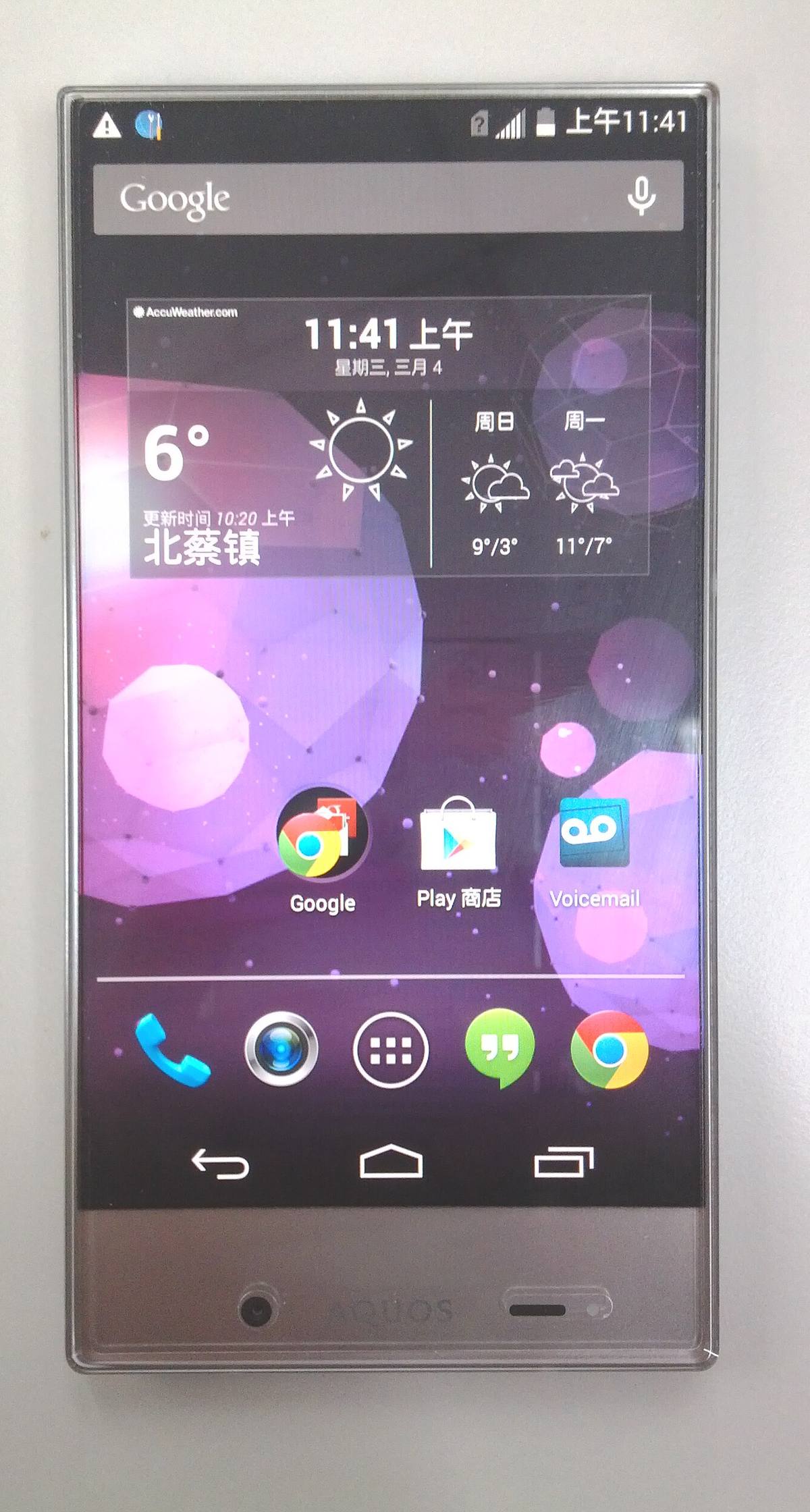 Přední strana telefonu Sharp Aquos Crystal se zapnutým displejem, nahoře a po stranách tenký rámeček, dole široká brada s kamerou a reproduktorem