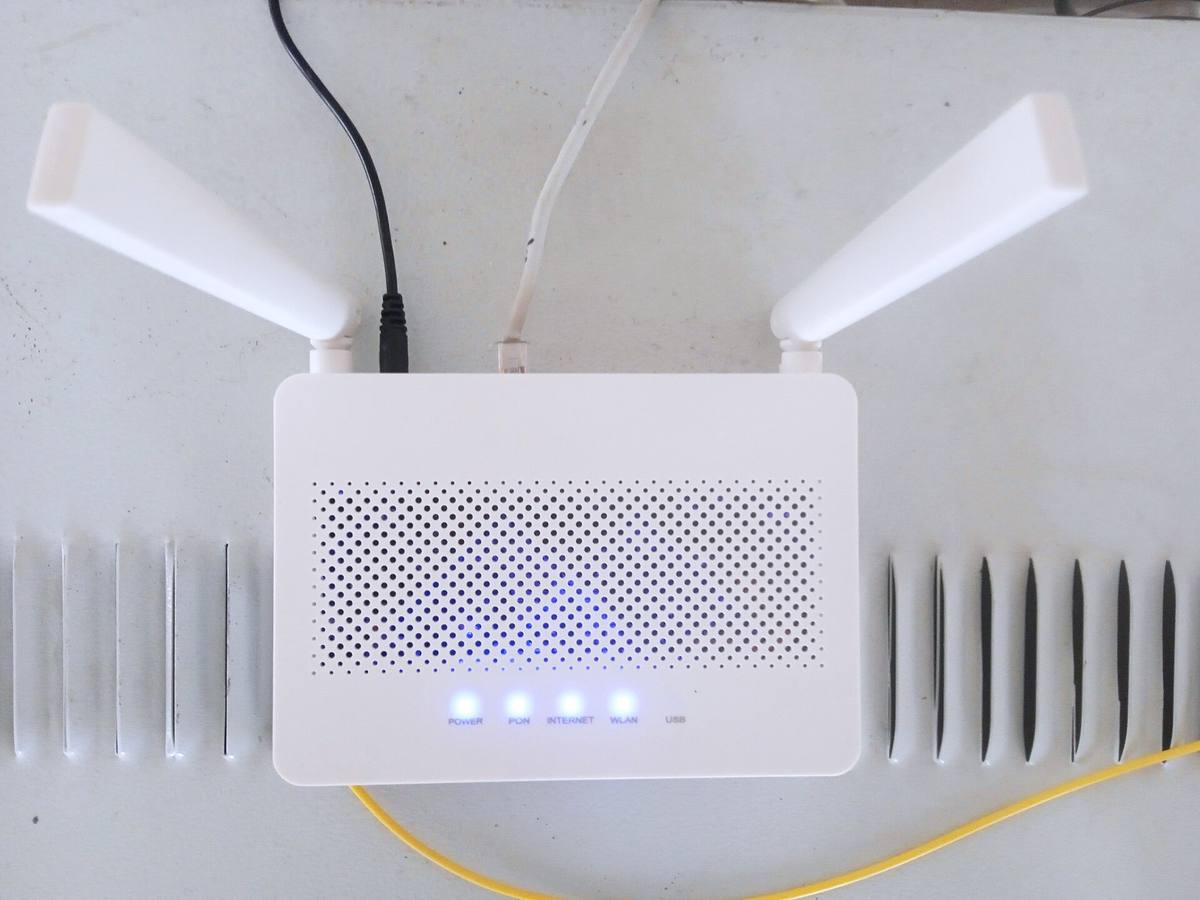 Domácí Wi-Fi router se čtyřmi anténami postavený na stole