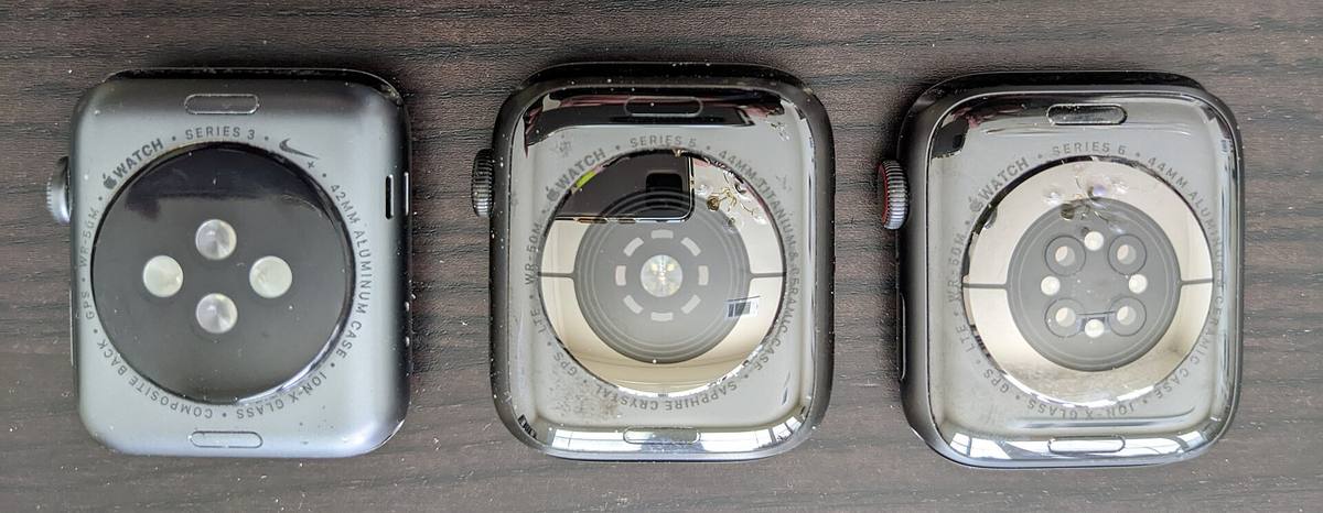 Zadní strany tří Apple Watch vedle sebe, na každé jiná sestava optických senzorů