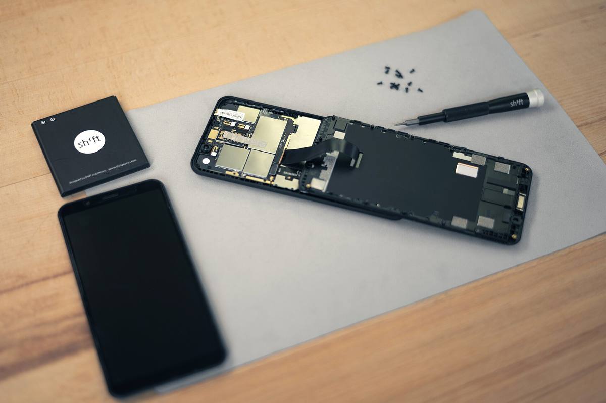 Rozebraný telefon Shift6mq, vedle něj náhradní displej, baterie a šroubovák