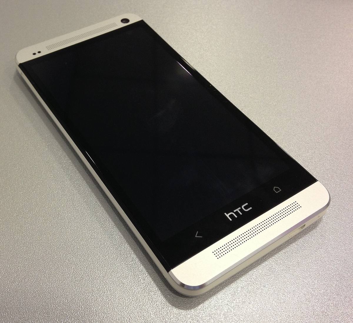 Hliníkový telefon HTC One položený displejem vzhůru