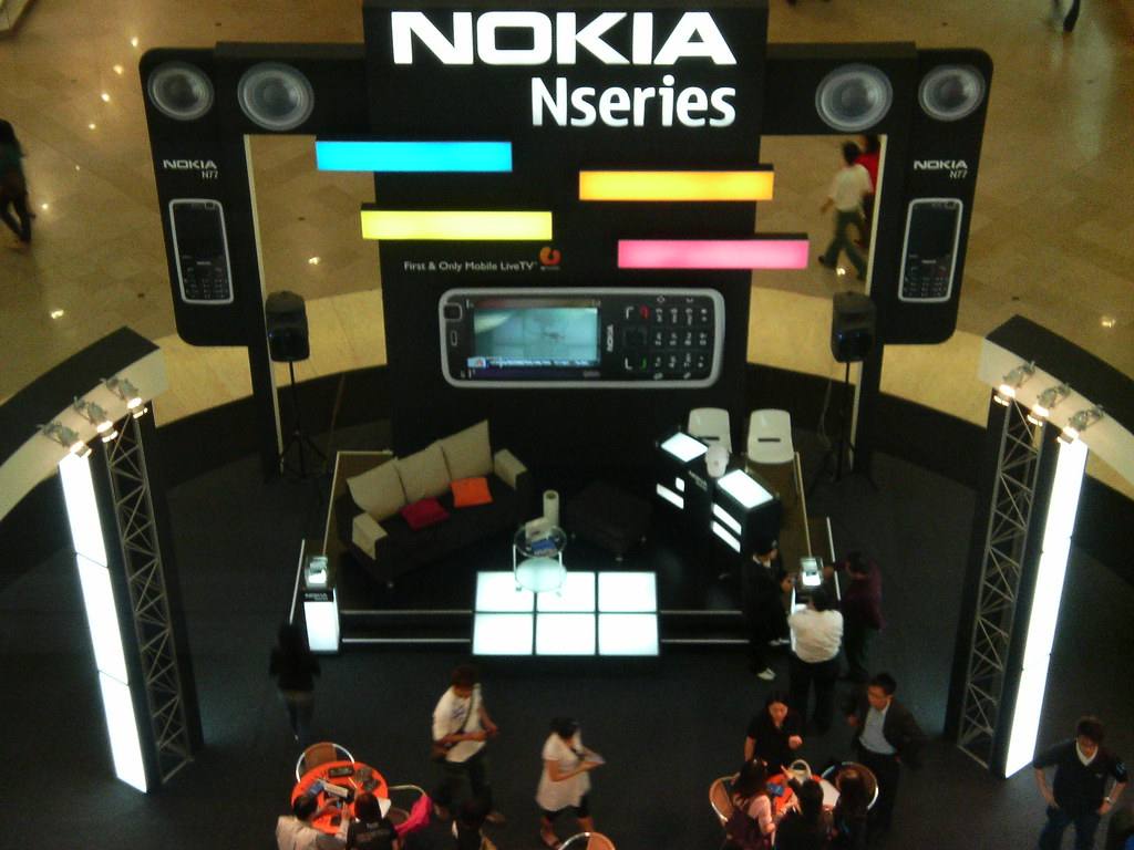 Propagační stánek Nokia Nseries v nákupním středisku, po stranách plakáty s telefonem N77