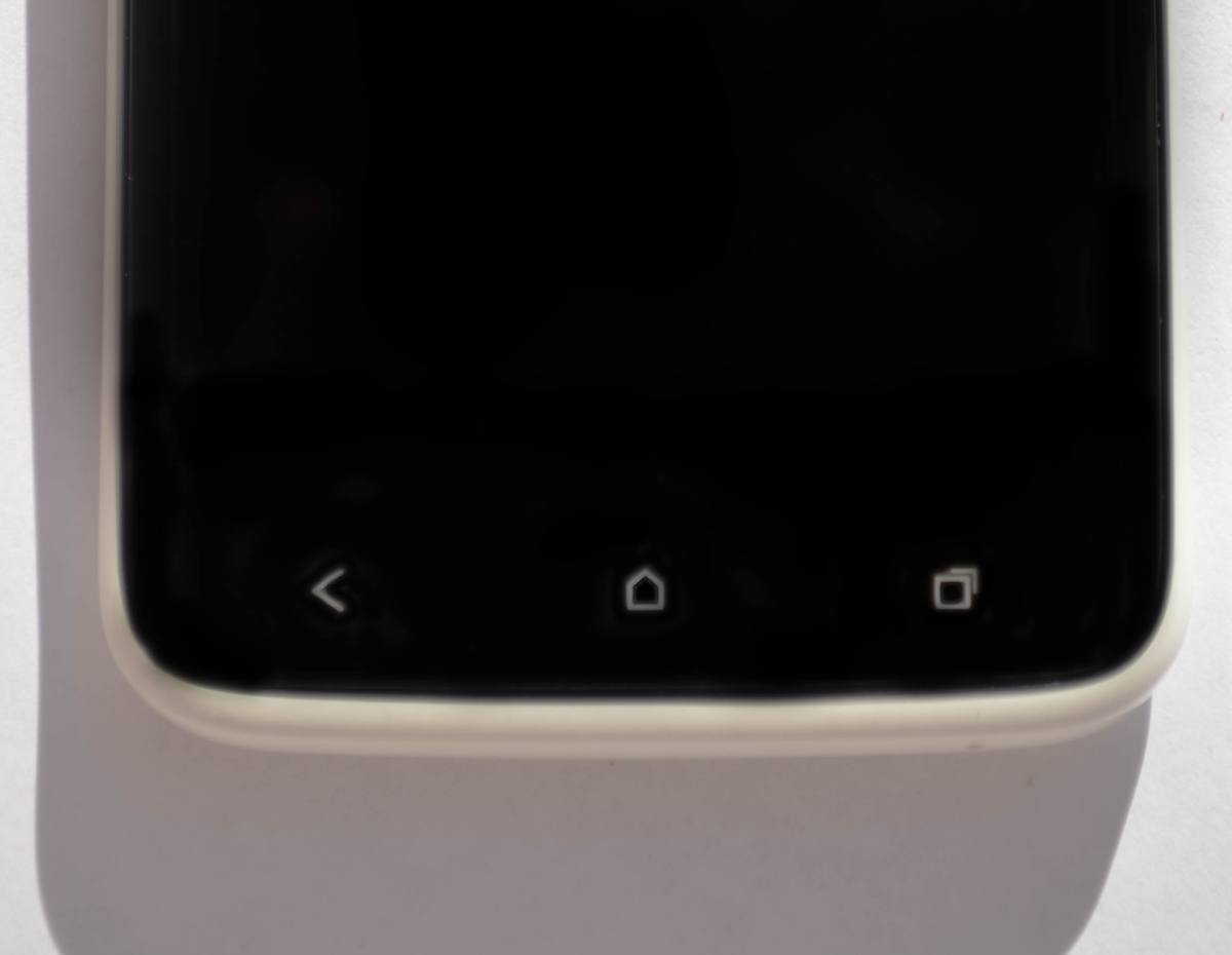 Spodní okraj displeje bílého telefonu HTC se třemi dotykovými značkami