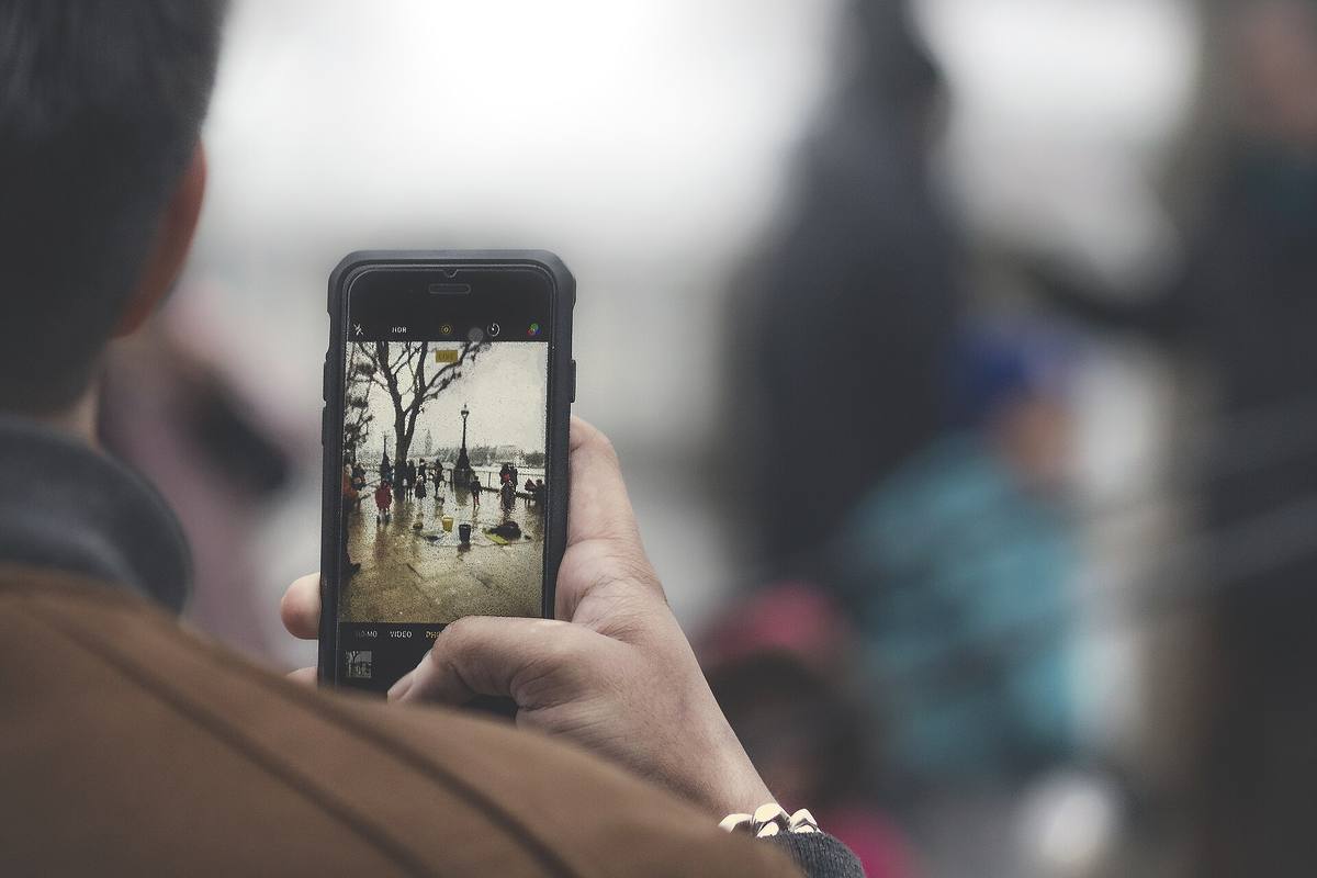 Ruka drží telefon a fotografuje
