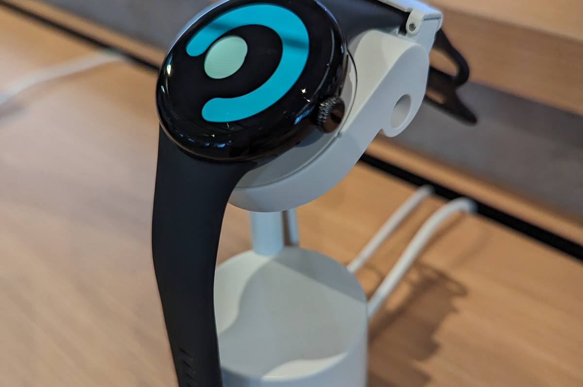 Chytré hodinky Google Pixel Watch s černým řemínkem na stojánku