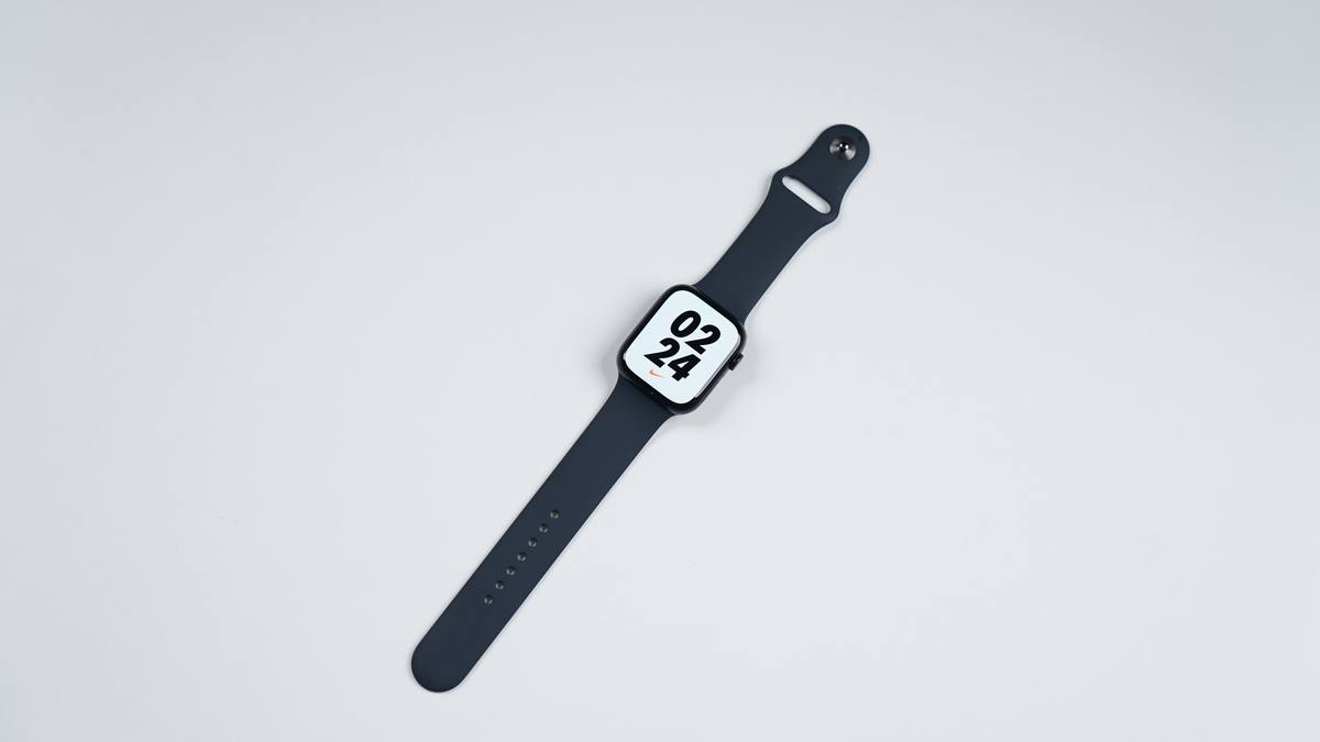 Hodinky Apple Watch s tmavým řemínkem na světlé podložce