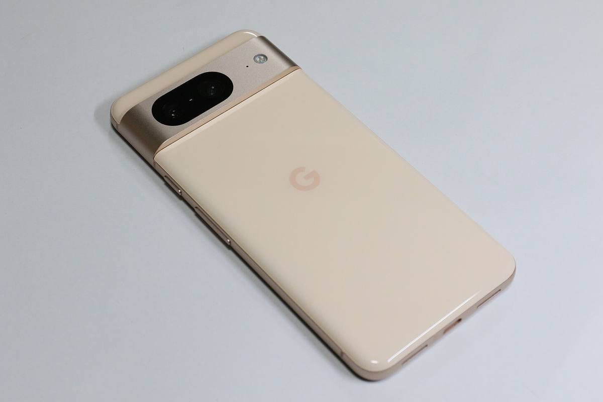Zadní strana telefonu Google Pixel 8 v růžové barvě, ležícího na bílé desce