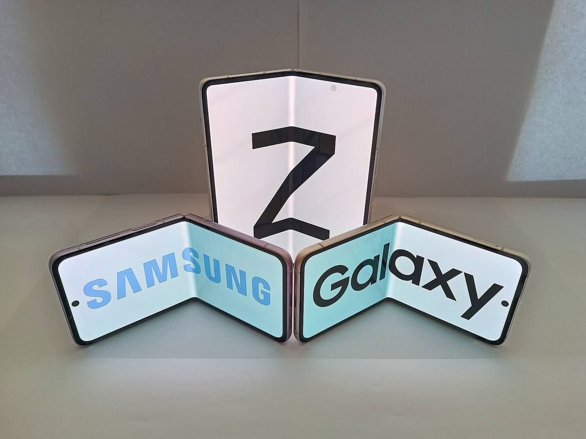 Rozevřený Galaxy Z Fold a dva Galaxy Z Flip postavené na stole